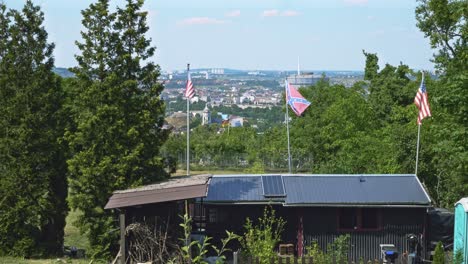 Amerikanische-Und-Konföderierte-Flaggen-Wehen-Im-Wind-Im-Grünen-Garten-über-Einer-Deutschen-Stadt