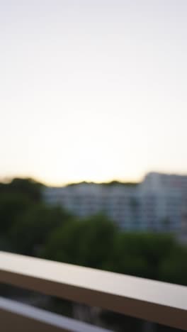 Vertical-shot-of-toast-and-cheers-with-beer-bottles-on-resort-balcony,-Mallorca