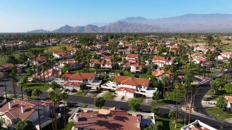 Aerial-dolly-over-golf-course-to-townhomes-with-patios-and-shared-pools-in-Palm-Springs-California-USA