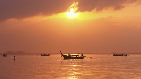 Man-comming-to-Long-Tail-boat-during-sunrise-in-Thailand,-Asia