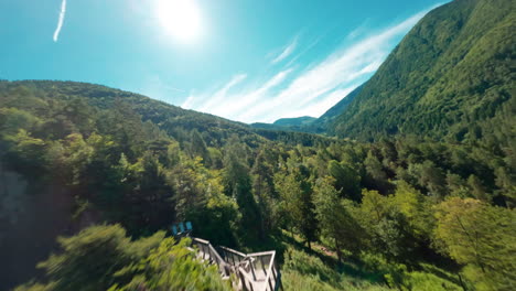 The-striking-Earth-Pyramids-of-Segonzano-set-against-a-backdrop-of-lush-green-mountains-on-a-sunny-day