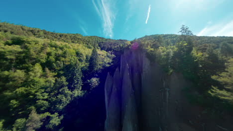 Unique-rock-formations-rise-from-lush-green-hills-under-a-bright-blue-sky