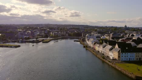 Luftparallaxe-Der-Farbenfrohen,-Sonnigen-Stadt-Galway,-Aufgenommen-Von-Der-Mündung-Des-Flusses-Corrib