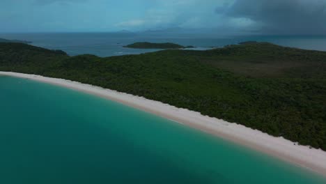 Whitehaven-Beach-white-sand-aerial-drone-Whitsundays-Island-Airlie-National-Park-Australia-AUS-QLD-rain-cloudy-blue-sky-outer-Great-Barrier-Reef-clear-blue-aqua-ocean-boat-yachts-forward-motion