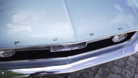 Close-up-of-a-classic-Ford-car-front-grille-and-emblem,-showcasing-vintage-automotive-design-and-chrome-details