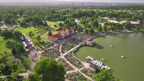 Vista-Aérea-En-Arco-Hacia-Atrás-Del-Evento-De-Jazz-Del-Parque-De-La-Ciudad-De-Verano-En-Denver-En-El-Lago-Ferril