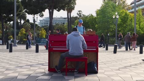 Vater-Und-Tochter-Schauen-Straßenmusikern-Zu,-Die-Am-Place-Massena-In-Nizza,-Frankreich,-Ein-Rotes-Klavier-Spielen