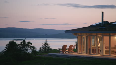 Casa-Elevada-Iluminada-Al-Anochecer-Con-Vistas-Al-Pintoresco-Estrecho-De-Mull,-Escocia