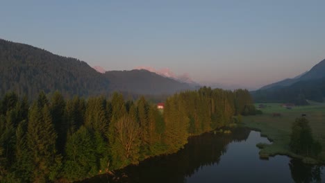 Wagenbrüchsee,-Alemania-Al-Amanecer-Con-árboles,-Montañas-Y-Casas-De-Pueblo-A-La-Vista,-Vista-Aérea