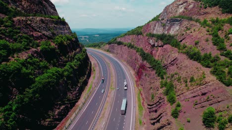 Flatbed-semi-truck-driver-loaded-with-freight-followed-by-reefer-trailer-rig