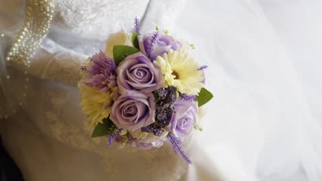 Slow-rising-shot-of-a-bride-holding-a-beautiful-pastel-themed-bouquet-of-flowers