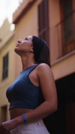 Vertical-shot-of-attractive-caucasian-female-tourist-stand-on-street-of-Mallorca