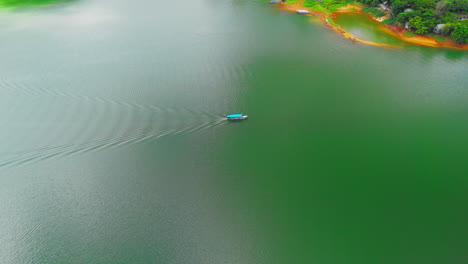 Una-Impresionante-Perspectiva-Aérea-Sigue-A-Un-Barco-Mientras-Se-Desliza-Por-Las-Aguas-Cristalinas-De-Un-Lago-De-Montaña-Aislado.