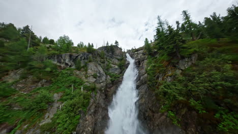 Ein-Atemberaubender-Wasserfall,-Der-In-Einer-Ruhigen-Naturlandschaft-Einen-üppig-Grünen-Berghang-Hinabstürzt