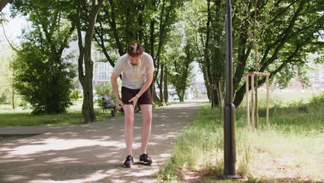 Hombre-Corredor-Atleta-Con-Dolor-Muscular-En-La-Pierna,-Lesión-Por-Traumatismo-Mientras-Trota,-Calambre-En-La-Pantorrilla,-Deporte-En-El-Parque-De-La-Ciudad