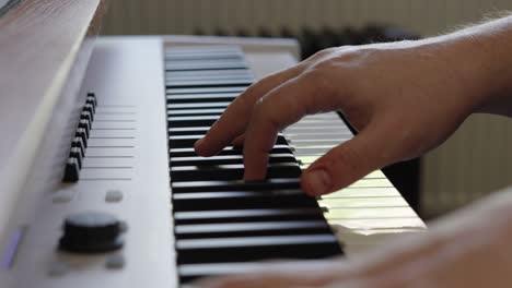 Male-Composer-Playing-on-Keyboard-Piano-Using-Various-Chords-to-Create-and-Record-Music-in-his-Studio