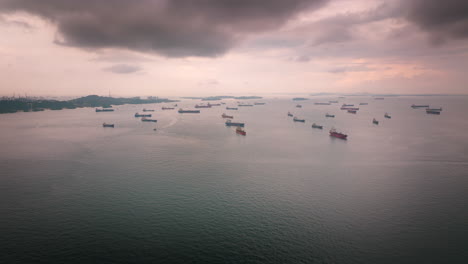 Panorama-Luftaufnahme-Von-Vielen-Containerschiffen,-Die-Vor-Dem-Hafen-Von-Singapur-Vor-Anker-Liegen