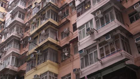 Old-Dense-Apartment-Buildings-Next-To-Modern-Condominiums,-Residential-Neighborhood-In-Hong-Kong,-Low-Angle-Panning-View