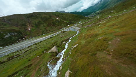 Vista-Aérea-De-Un-Arroyo-De-Montaña-En-Cascada-Cerca-De-Cervinia-En-Medio-De-Exuberantes-Colinas-Verdes