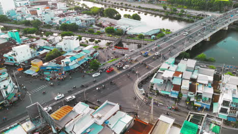 Watch-as-a-constant-stream-of-motorbikes-and-cars-traverse-a-bridge,-creating-a-mesmerizing-pattern-of-movement-against-the-backdrop-of-a-vibrant-sunset