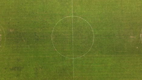 Top-down-view-of-a-football-field,-ascending-from-the-center,-located-in-Rapperswil-Jona,-Zürichsee,-Switzerland,-illustrating-the-concept-of-sports-and-active-community-engagement