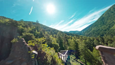 Piramidi-di-Terra-di-Segonzano-in-a-lush-green-valley-under-a-bright-blue-sky-and-shining-sun