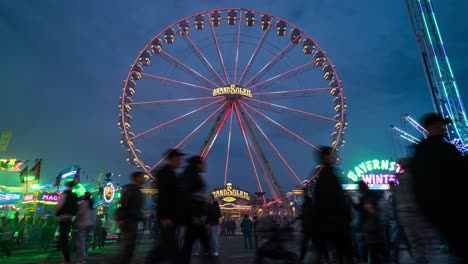 Zeitrafferaufnahme-Einer-Menschenmenge,-Die-Nicht-Wiederzuerkennen-Ist,-Und-Beleuchteter-Fahrgeschäfte-In-Einem-Belebten-Vergnügungspark