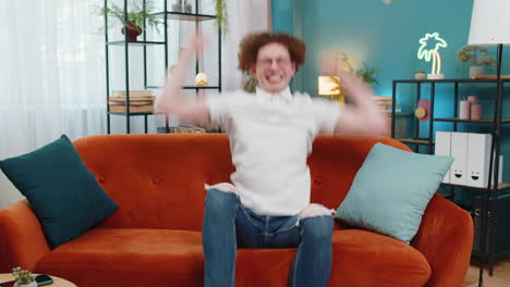 Portrait-of-excited-young-man-celebrating-success-looking-at-camera-good-news-victory-watching-TV