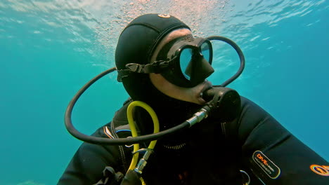 Vídeo-De-Primer-Plano-De-Un-Hombre-Caucásico-Con-Equipo-De-Buceo,-Bajo-El-Agua,-Explorando-La-Vida-Marina-Que-Lo-Rodea.