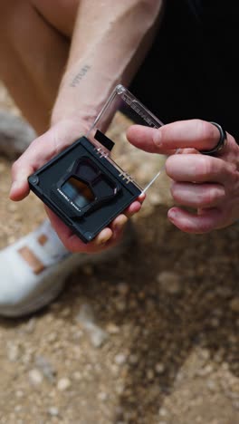 Vertical-shot-of-male-hold-in-hands-nd-filter-case-and-open-lid,-Mallorca