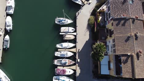 Marina-port-harbour,-small-boats-moored,-top-down-aerial-drone-view