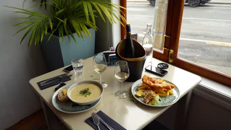 Romantic-table-setting-for-two-with-Fish-and-Chips-and-Seafood-Chowder-in-a-restaurant