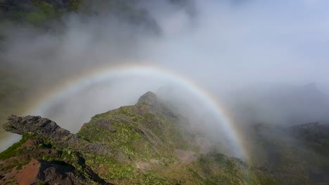 Rainbow-over-mountain-ridge-with-clouds-and-sunlight