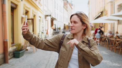 Woman-blogger-taking-selfie-on-smartphone,-communicating-video-call-online-with-subscribers-in-city