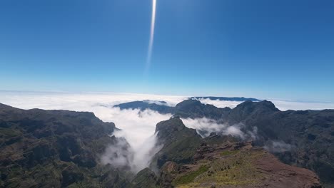 High-altitude-view-of-mountain-peaks-and-clouds-hanging-in-valley