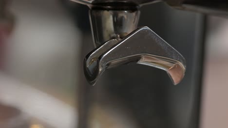 Сoffee-pouring-from-holder-into-espresso-cup,-macro-espresso-making-process