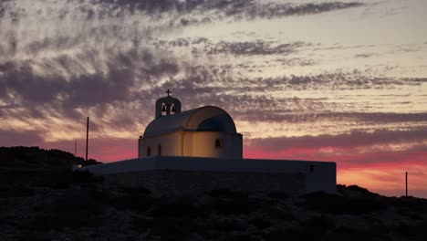 Holy-Wisdom-church-in-Donousa-Greece-glows-from-lights-on-building-at-dusk