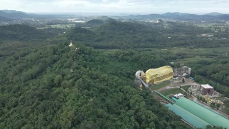 Reclining-Buddha-and-Stupa-on-Top-of-a-Hillside-Surrounded-with-Forest-Trees-in-Saraburi,-Thailand