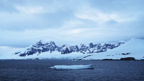 Aerial-drone-shot-of-Antarctica-Scenery-and-Mountains-on-the-Antarctic-Peninsula,-Beautiful-Winter-Mountain-Range-and-Landscape-Covered-in-Snow-and-Ice-in-the-Snowy-Southern-Ocean