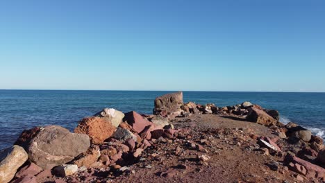 Walking-POV-on-sea-separation-Groynes,-rocky-patch-separating-the-water