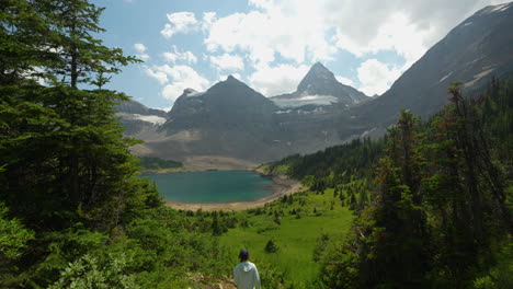 Woman-on-Hiking-Trail-Above-Lake-in-Green-Landscape-of-Mount-Assiniboine,-Canada