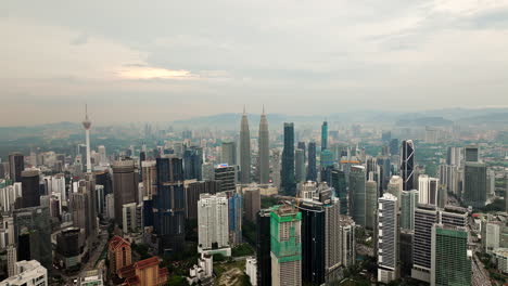 Kuala-Lumpur-city-skyline-with-skyscrapers-and-Petronas-Towers-in-middle,-aerial