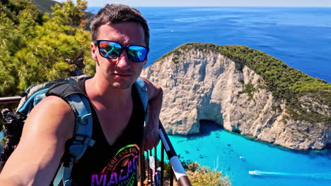 Portrait-Of-A-Tourist-At-The-Viewing-Point-At-Shipwreck-Beach-During-Summer-In-The-Ionian-Islands-of-Greece