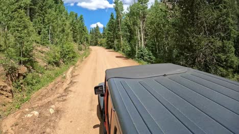 POV---View-of-vehicle-rooftop-driving-on-a-scenic-gold-belt-byway-in-Rocky-Mountains