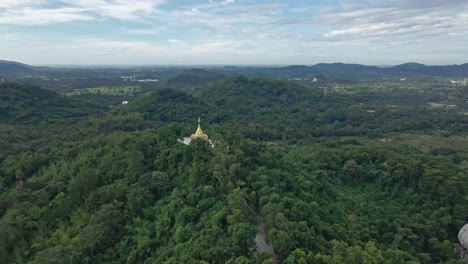 Phra-Maha-Chedi-Thep-Nithakorn,-Ein-Goldener-Tempel-Auf-Einem-Hügel-Mit-Grünen-Waldbäumen,-Saraburi,-Thailand