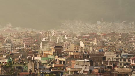 Kathmandu-City-Cityscape-in-Nepal,-Beautiful-Light-View-of-Kathmandu-City-with-Houses-and-Buildings-and-Sunrise-Morning-Golden-Orange-Sunlight,-Elevated-Aerial-View