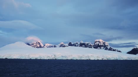 Antarctica-Winter-Mountains-at-Sunset,-Dramatic-Clouds-and-Sky-in-Beautiful-Coastal-Scenery-and-Glacier-at-Sunrise-on-Antarctic-Peninsula-Coast,-Amazing-Landscape-and-Ocean-Sea-Water-Seascape