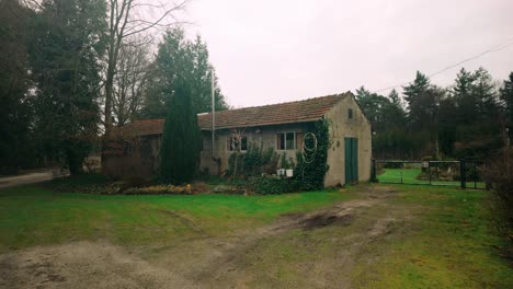 Charming-and-artistically-decorated-farmhouse-nestled-in-serene-countryside-of-North-Brabant,-Picturesque-setting,-with-greenery-and-rustic-details-highlighting-farmhouse's-unique-character