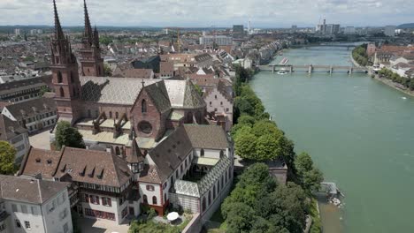 Vídeo-De-Dron-En-4K-De-Una-Antigua-Iglesia-A-Orillas-Del-Río-Rin-En-El-Centro-De-Basilea,-Suiza