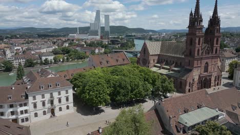 Vídeo-De-Dron-En-4K-De-Una-Iglesia-Gótica-A-Orillas-Del-Río-Rin-En-Basilea,-Suiza